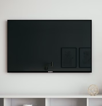 Expert NOBO utilisant une microfibre pour nettoyer un écran TV OLED dans un salon moderne.