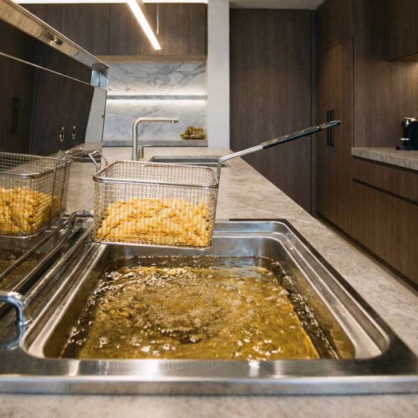 Expert en train de dégraisser une friteuse en inox pour un résultat impeccable.